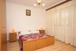 a bedroom with a bed and a window with curtains at Apartments with a parking space Sali, Dugi otok - 910 in Sali
