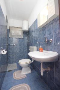 a blue tiled bathroom with a toilet and a sink at Apartments with a parking space Sali, Dugi otok - 910 in Sali