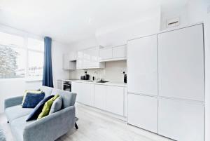 a living room with a couch and a kitchen at Chic 1BR Thornton Flat - Charm and City Access in Thornton Heath