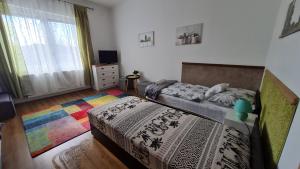 1 dormitorio con 2 camas y alfombra de arco iris en Dunakeszi Nap Apartman, en Dunakeszi