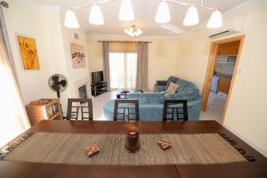 a living room with a table and a couch at Vela - Apartment in complex near the beach in São Martinho do Porto