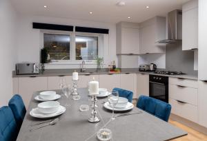 a kitchen with a dining table with blue chairs at Deluxe South Central Apartment in London