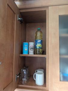 a cupboard with a bottle of water and cups at Dudley Rooms in Tipton