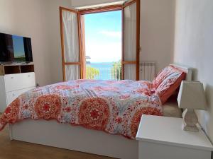 - une chambre avec un lit et une grande fenêtre dans l'établissement Moderna Casa Fronte Mare, à Cogoleto
