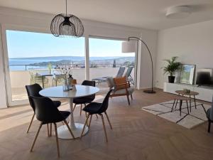 a living room with a table and chairs and a large window at Sea View Apartments Ivana in Krk