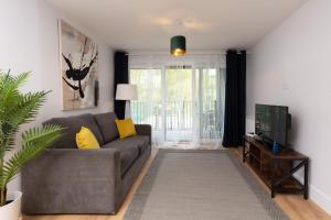 a living room with a couch and a tv at Deluxe South Central Apartment in London