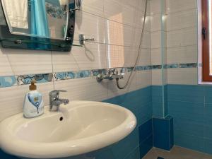 a bathroom with a sink and a mirror at Brami Apartment in Berat