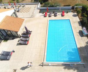 an overhead view of a swimming pool with chaises and chairs at Hôtel des Dunes Noirmoutier in La Guérinière