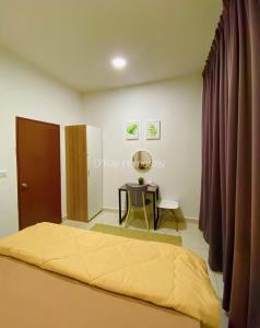 ein Schlafzimmer mit einem Bett und einem Tisch darin in der Unterkunft Mesahill Studio Deluxe King by DKAY in Nilai in Nilai