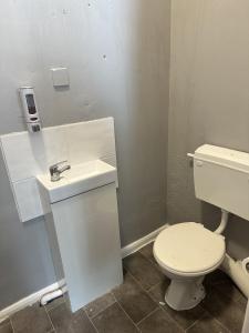 a bathroom with a white toilet and a sink at The Majestic in Great Yarmouth