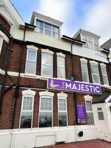 un bâtiment en briques avec un panneau violet sur lui dans l'établissement The Majestic, à Great Yarmouth