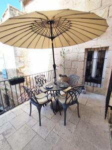 a table and chairs with a large umbrella on a balcony at La Terrasse du Pont du Gard in Saint-Bonnet-du-Gard