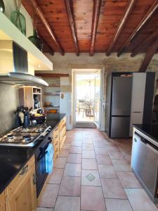 a kitchen with a stove and a refrigerator at La Terrasse du Pont du Gard in Saint-Bonnet-du-Gard