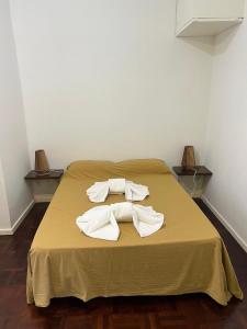 a bed with two white towels on top of it at Share in Buenos Aires