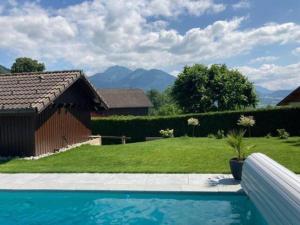 - une piscine dans une cour avec une maison dans l'établissement Chalet avec vue panoramique sur les Montagnes du Mole et la chaîne des Aravis piscine chauffée à 5 min des pistes de la station des Brasses, à Viuz-en-Sallaz