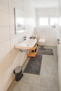 ein weißes Bad mit einem Waschbecken und einem WC in der Unterkunft Coworking und Seminarhaus in Diessen am Ammersee in Dießen am Ammersee