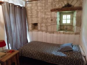 圣博泽伊Gite Les 3 Toitures Ecogite le Luquet Saint Beauzeil 82的带床和窗户的卧室