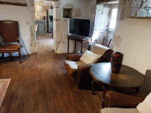 sala de estar con sofá y mesa en Gite Les 3 Toitures Ecogite le Luquet Saint Beauzeil 82 en Saint-Beauzeil