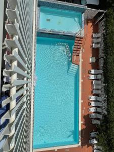 una vista aérea de una piscina entre dos edificios en Hotel Delfino, en Milano Marittima