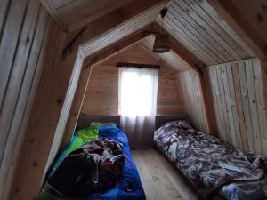 Habitación con 2 camas en una casa de madera en Cloudtop hut, en Gomi