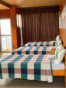 1 Schlafzimmer mit 2 Betten und einem Fenster in der Unterkunft Wanay's Rocky Mountain Homestay in Baguio City