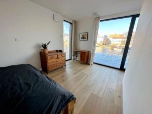 een slaapkamer met een bed en een grote glazen schuifdeur bij One of the kind Prague Houseboat Experience +BOAT in Praag