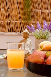 un vaso de zumo de naranja junto a un plato de fruta en Jasmine Apartment - Your Perfect Nafplio Escape, en Nauplia