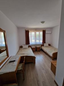 a room with two beds and a table in it at Престиж in Arbanasi