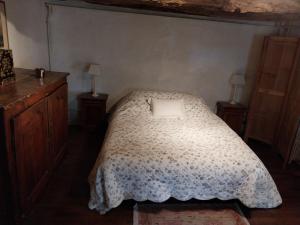 1 dormitorio con 1 cama, 2 mesas y 2 lámparas en Gite Les 3 Toitures Ecogite le Luquet Saint Beauzeil 82, en Saint-Beauzeil