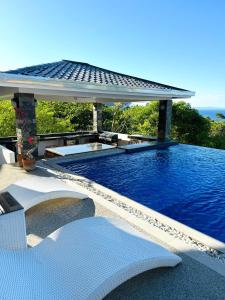 een groot zwembad met een paviljoen op een resort bij 2 Bedroom Suite with private pool and amazing view in Puerto Galera
