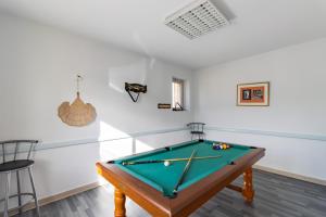 a pool table in a room with white walls at Gîte Piscine et Jacuzzi intérieurs in Cherveix-Cubas