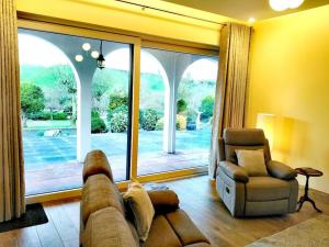 a living room with a couch and a chair and a large window at Annalee House, Knappagh Valley - 1 hour to Airport in Shercock