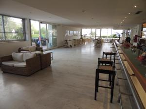 uma grande sala com sofás e cadeiras e mesas em Hotel Select em Marina di Campo