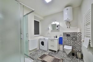 a bathroom with a sink and a washing machine at Apartamenty KOMBI in Nowy Targ