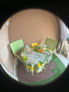 una mesa con sillas verdes y una mesa con comida. en Larcobaleno di Chia en Domus de Maria