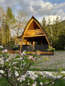 a small cabin in a yard with flowers at U Yaroslava Hotel in Yaremche