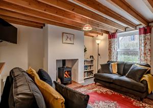 a living room with a couch and a fireplace at Cobbley Cottage in Little Snoring
