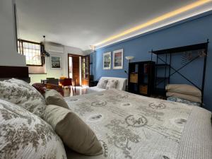 Un dormitorio con una cama y una pared azul. en Loft - Lago di Como Apt, en Menaggio