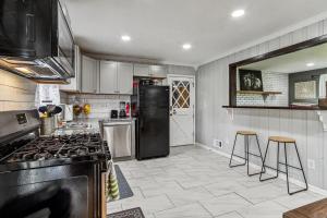 een keuken met een zwarte koelkast en krukken. bij Spacious 4BR Marietta Home, Perfect for Families in Marietta