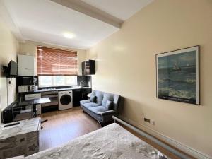 a living room with a couch and a chair at Comfy Apartments - Finchley Road in London