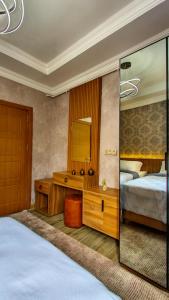1 dormitorio con 2 camas, escritorio y espejo en Denis suit apart en Estambul