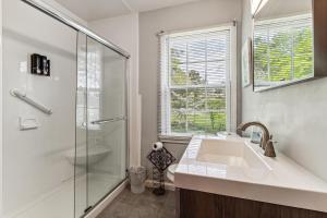 y baño blanco con lavabo y ducha. en Spacious 4BR Marietta Home, Perfect for Families, en Marietta