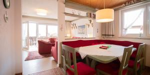 ein Esszimmer mit einem Tisch und roten Stühlen in der Unterkunft Försterhäusl in Seefeld in Tirol