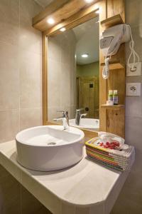 eine Badezimmertheke mit einem Waschbecken und einem Spiegel in der Unterkunft Hotel Royam in Saly Portudal