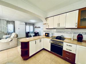 ミアミ・プラトーヤにあるVilla Vistaの白いキャビネット付きのキッチン、リビングルーム
