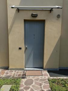Appartamento Aeroporto e Fiera في سيرياته: باب أزرق على مبنى أرضيته حجرية
