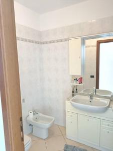 Appartamento Aeroporto e Fiera في سيرياته: حمام أبيض مع حوض ومرحاض