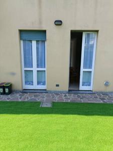 a house with two doors and a green lawn at Appartamento Aeroporto e Fiera in Seriate