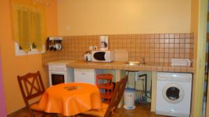 een keuken met een tafel en een magnetron bij Location Alpinia in Saint-Paul