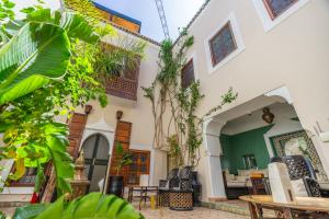 un patio con sillas y mesas en un edificio en Riad El Youssoufi, en Marrakech